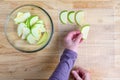 WomanÃ¢â¬â¢s hands taking granny smith apple slices out of a glass bowl and laying them out on a mesh tray for dehydrating Royalty Free Stock Photo